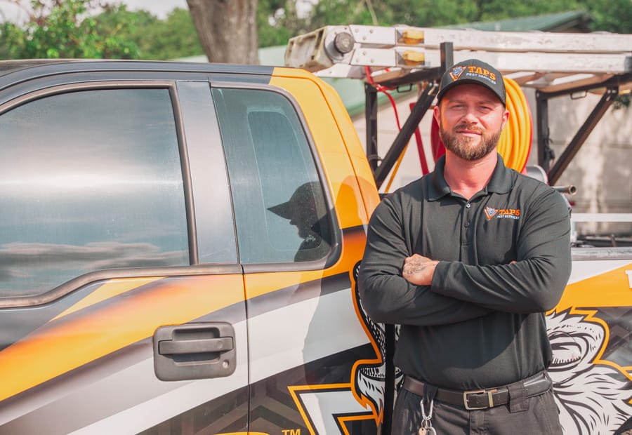 Taps technician beside the Taps Pest Services truck in Riverview, FL