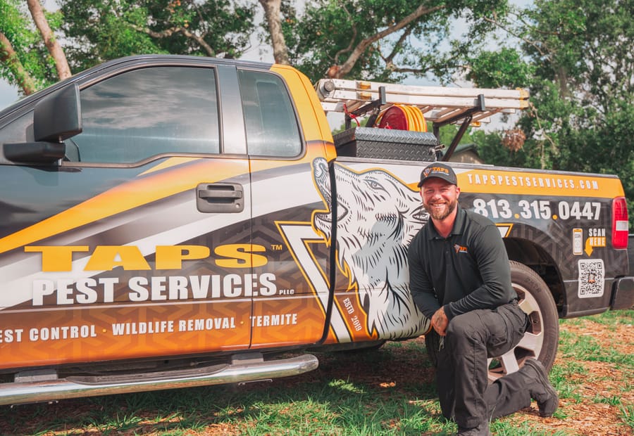 Taps technician with the wolf-wrapped pest control truck in Riverview, FL