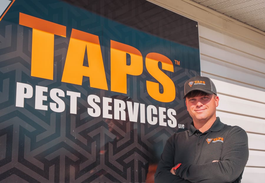 Taps technician in front of Taps Pest Services branding, serving Brandon, FL