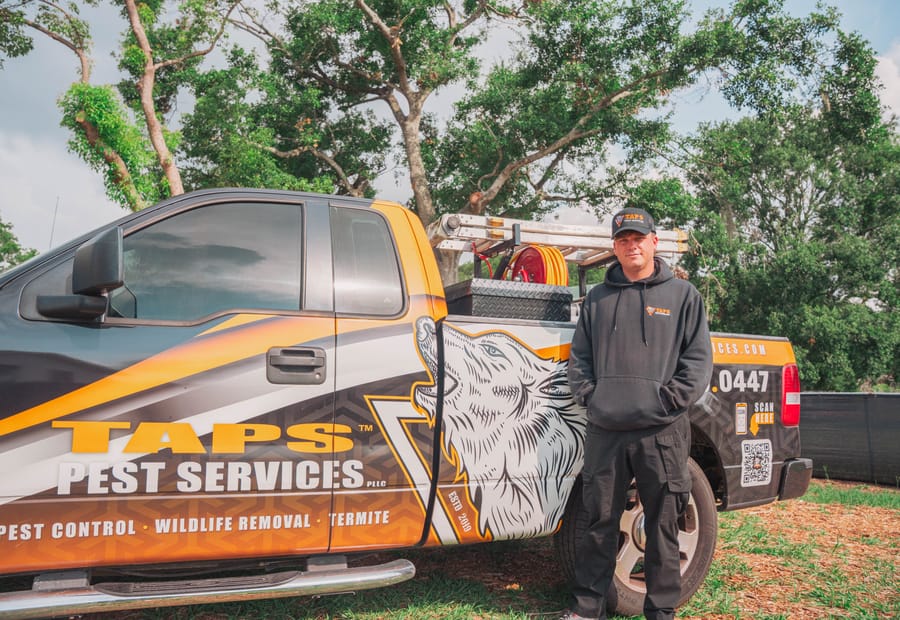Taps Pest Services wolf-wrapped truck with technician in Riverview, FL