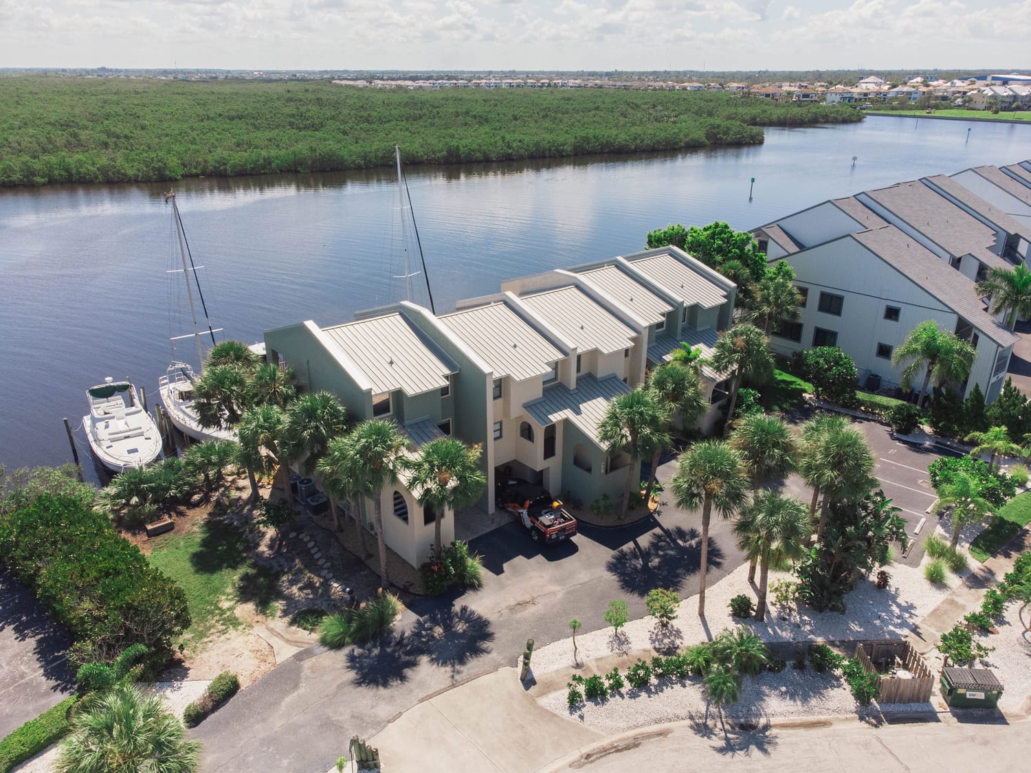 Aerial view of a waterfront condominium community serviced by a Taps Pest Services truck across Tampa Bay, FL