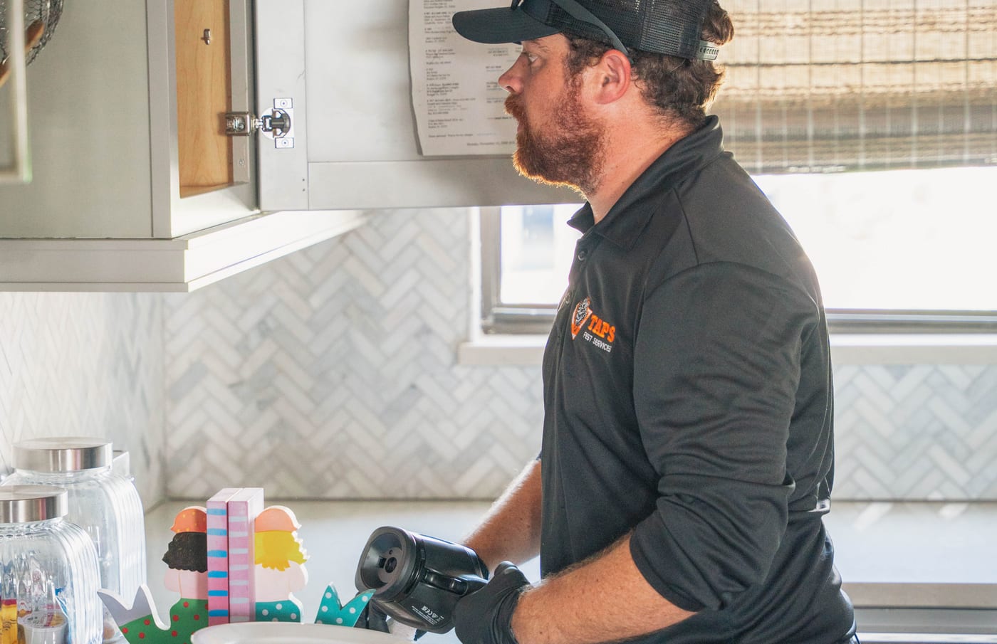 Taps Pest Services technician inspecting kitchen cabinets during a general pest control visit in Riverview, FL