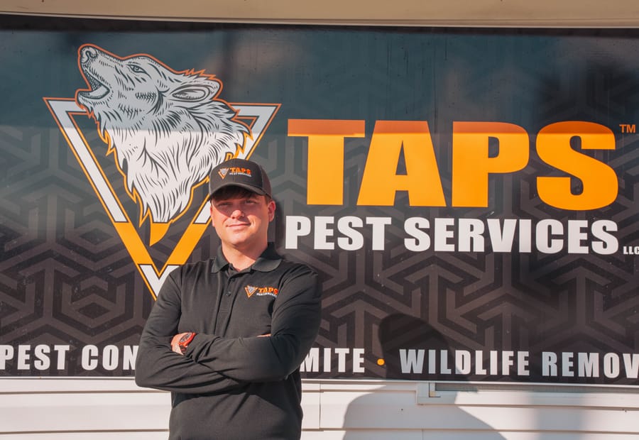Taps Pest Services technician in front of the company's branding in Riverview, FL