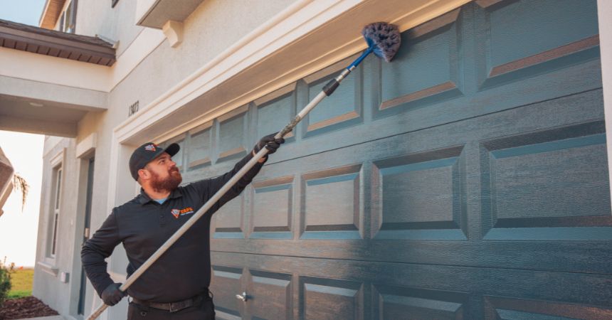 Technician performing quarterly pest control in Apollo Beach, Florida, removing webs and inspecting a residential home for pests.